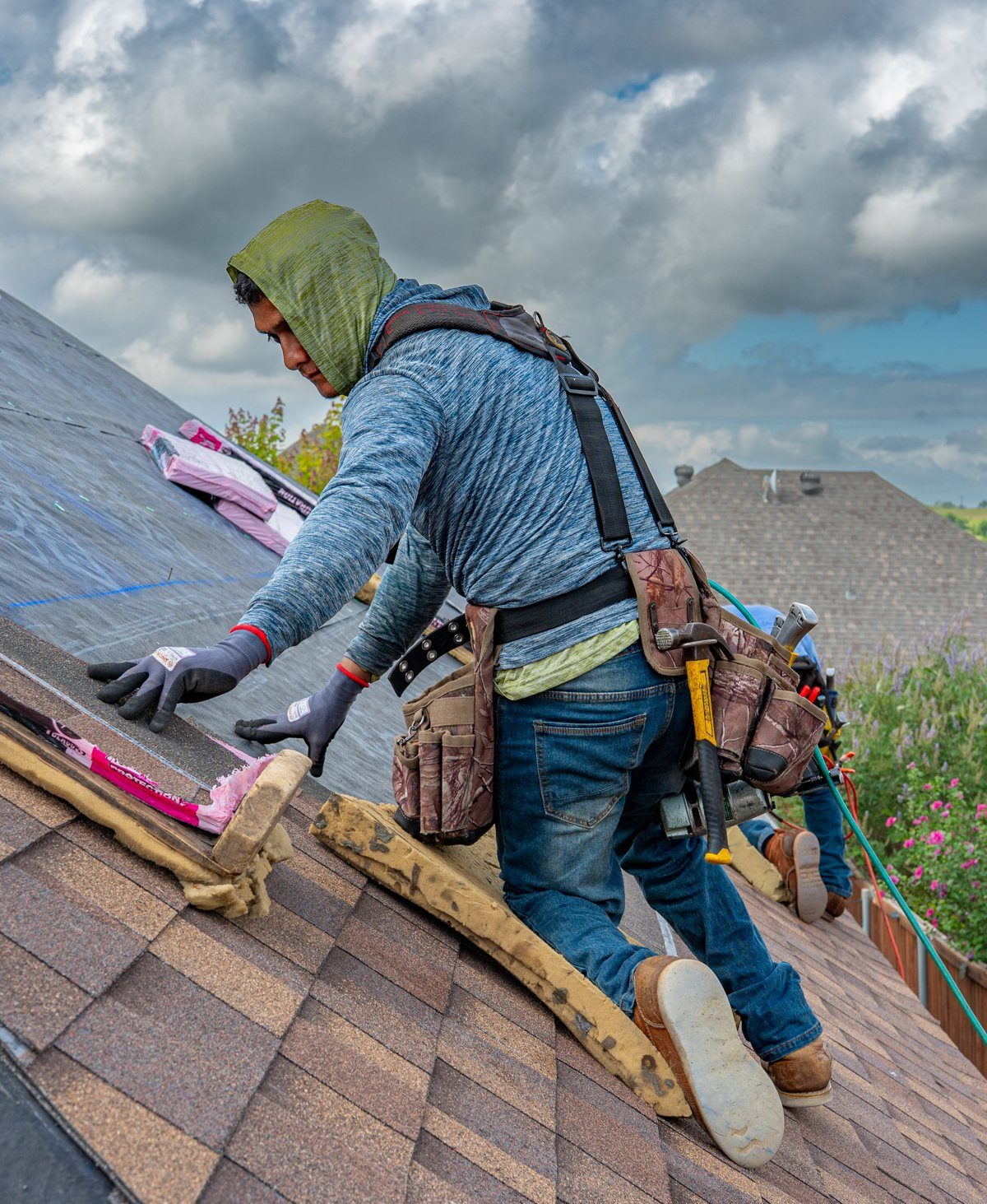 A roofer installing shingles on a roof